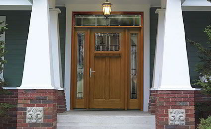 Porta de entrada clássica feita com madeira e vidro.